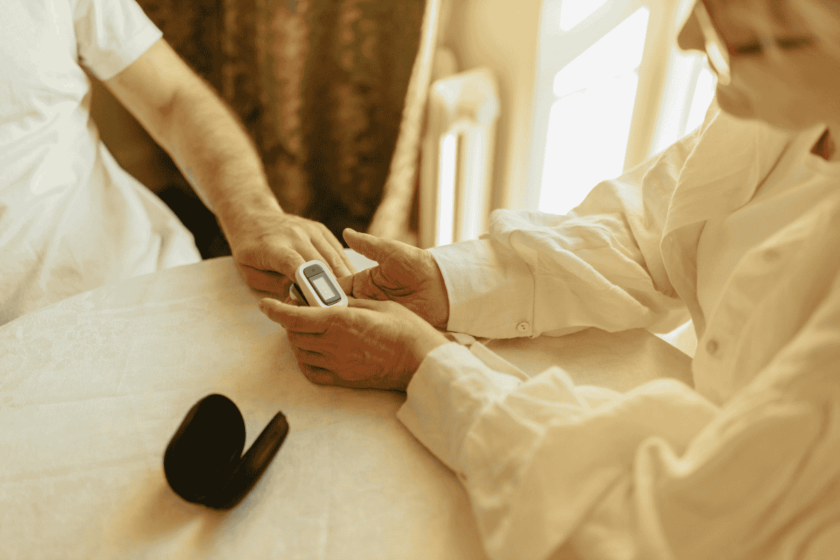 Senior holding a medical alert device while discussing how much is life alert cost at home